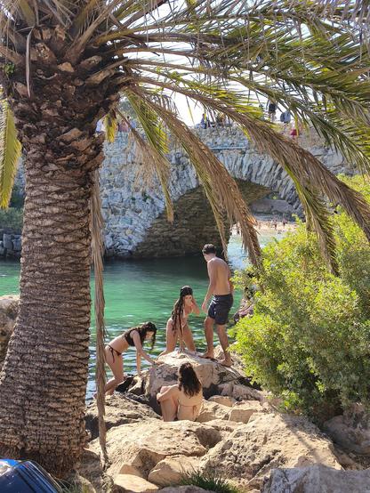 Swimmers climb rocks.